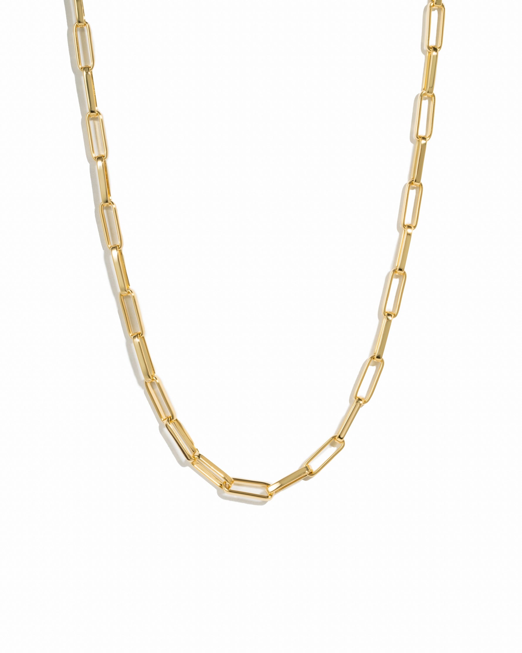 Gold square statement paperclip necklace on white background.