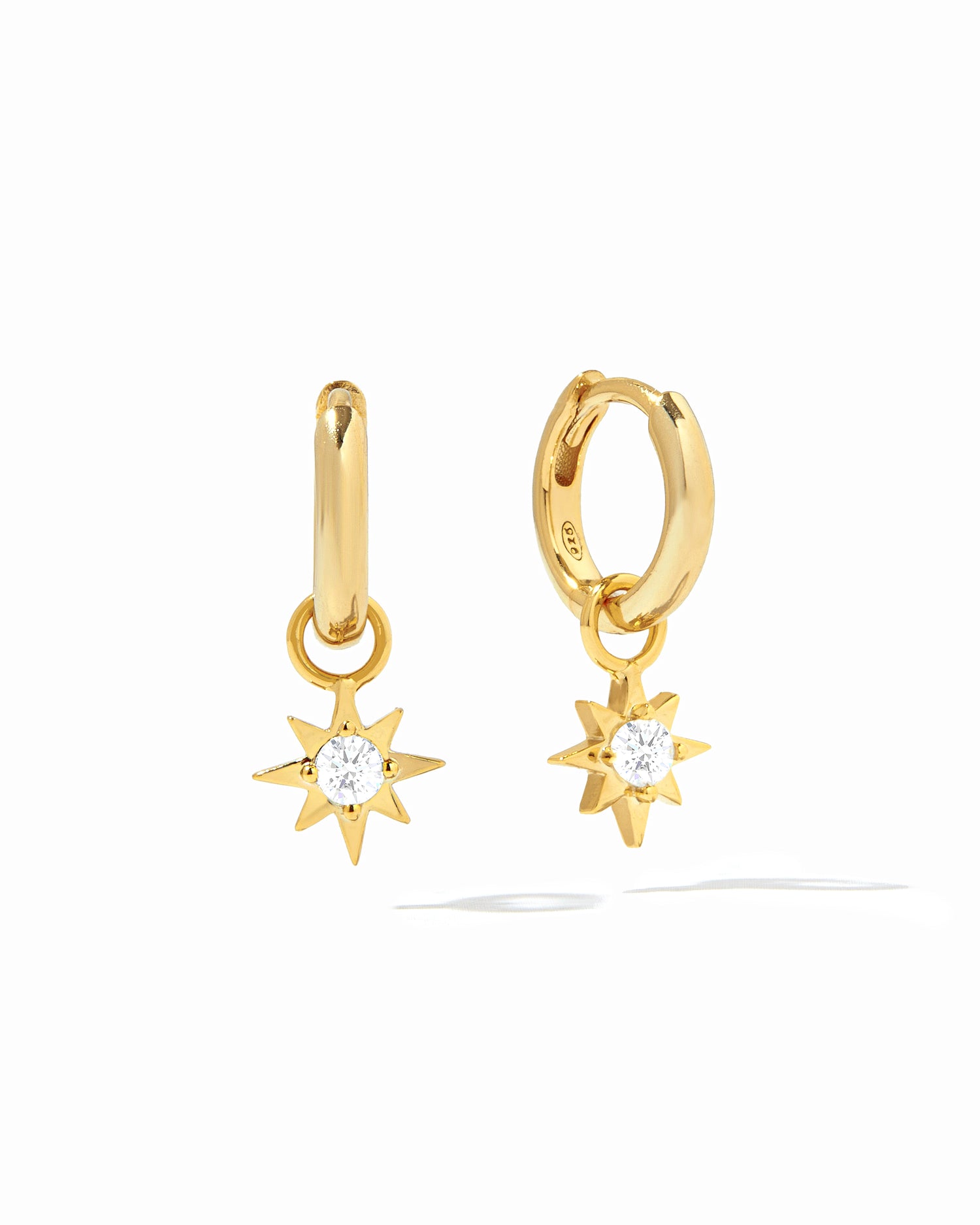 Dainty gold sunburst charm earrings with removable charm on white background.