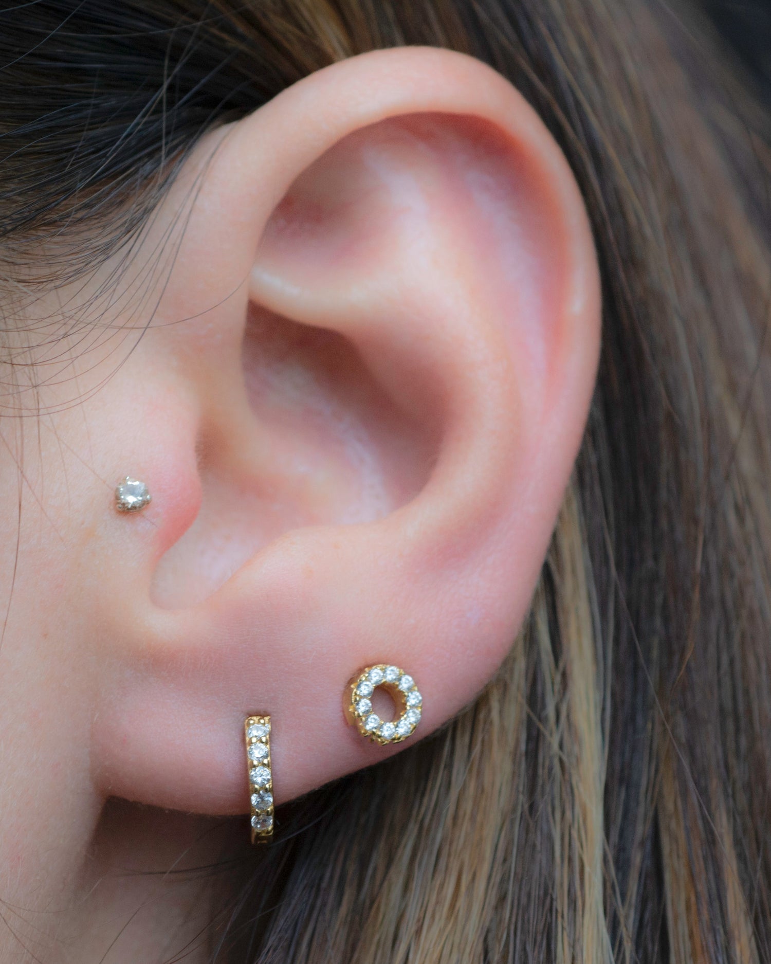 Model wearing gold studded earrings 