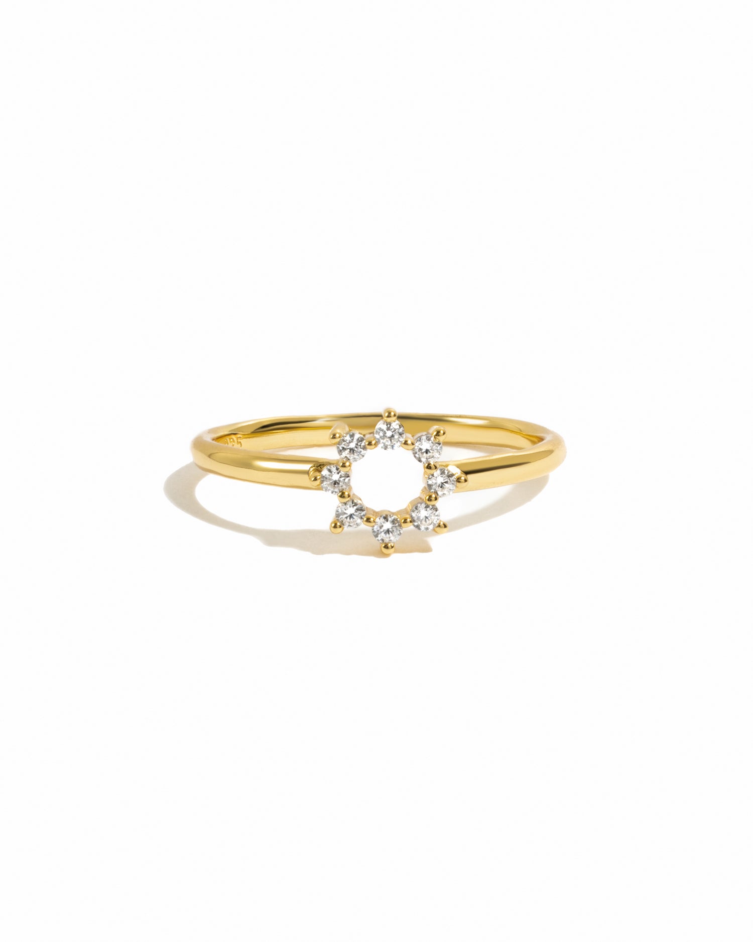 Gold sunburst cz dainty ring on white background. 