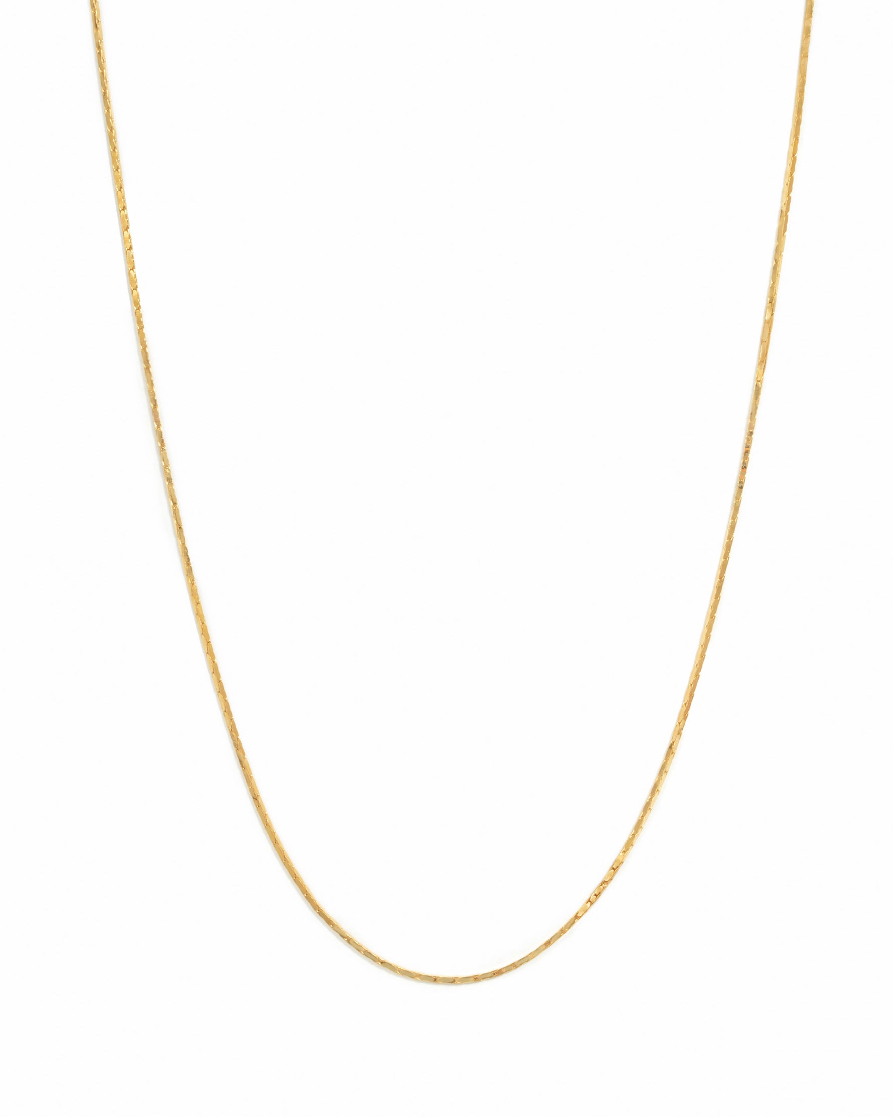 Delicate gold thin chain necklace on white background