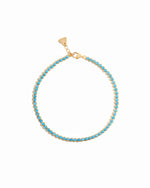 Gold turquoise round tennis anklet on white background