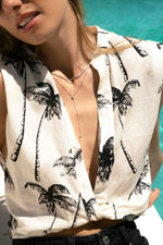 Model wearing beachy silver layered necklace stack featuring a silver thin rope chain necklace paired with a pear lariat necklace.