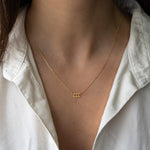 Model wearing delicate gold stacking angel number necklace in the number 111
