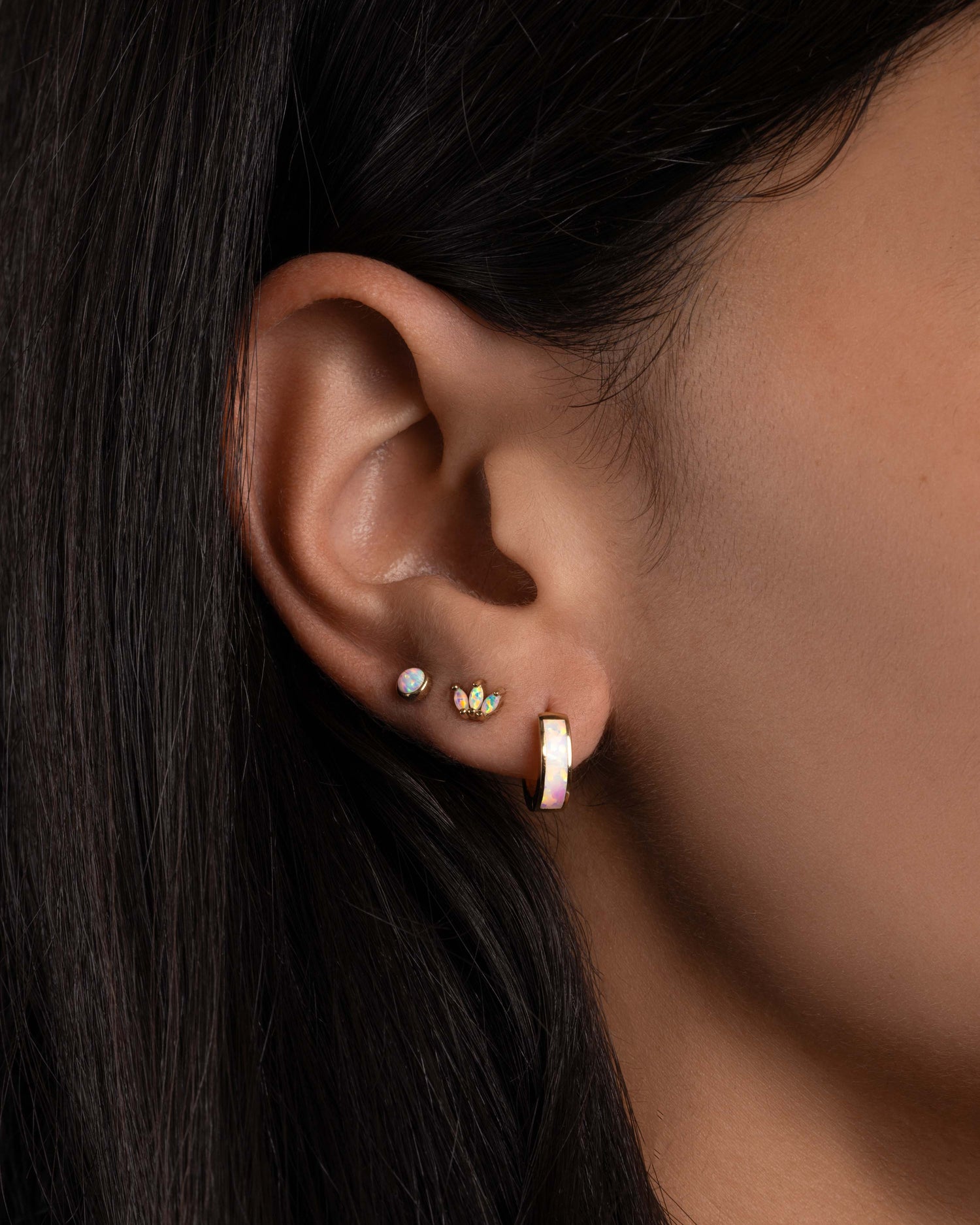 Model wearing dainty opal earrings.