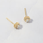 Opal sunburst cz stud earrings from the side angle on marble background. 