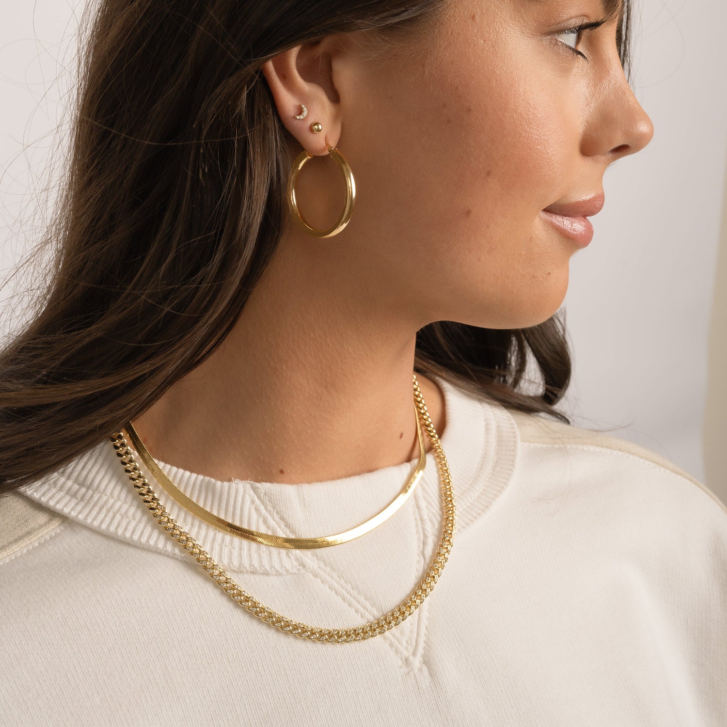 Model wearing pavé curb chain necklace in gold.