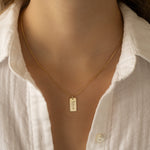 Model wearing dainty gold custom dog tag name necklace
