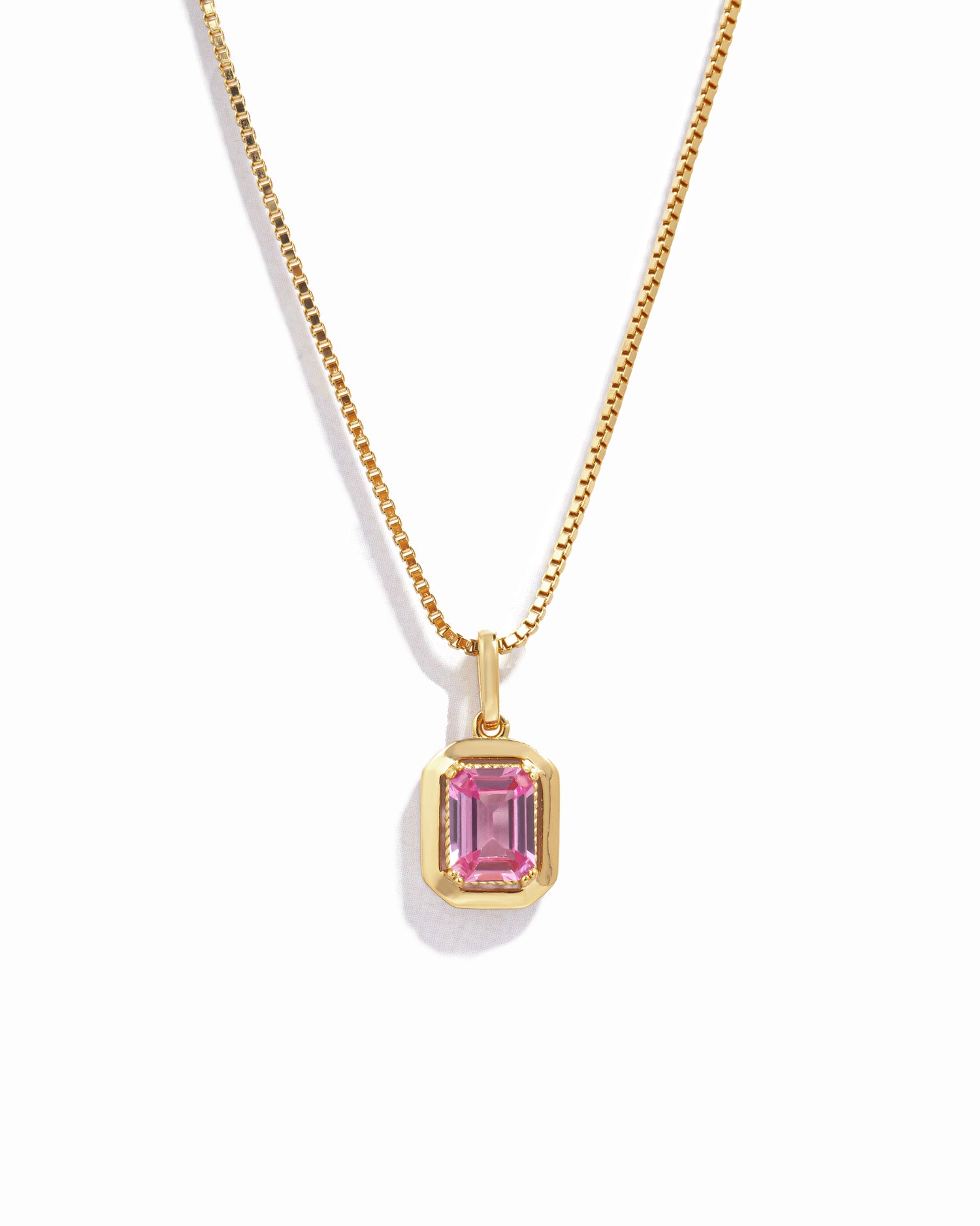 gold pink necklace on box chain on white background