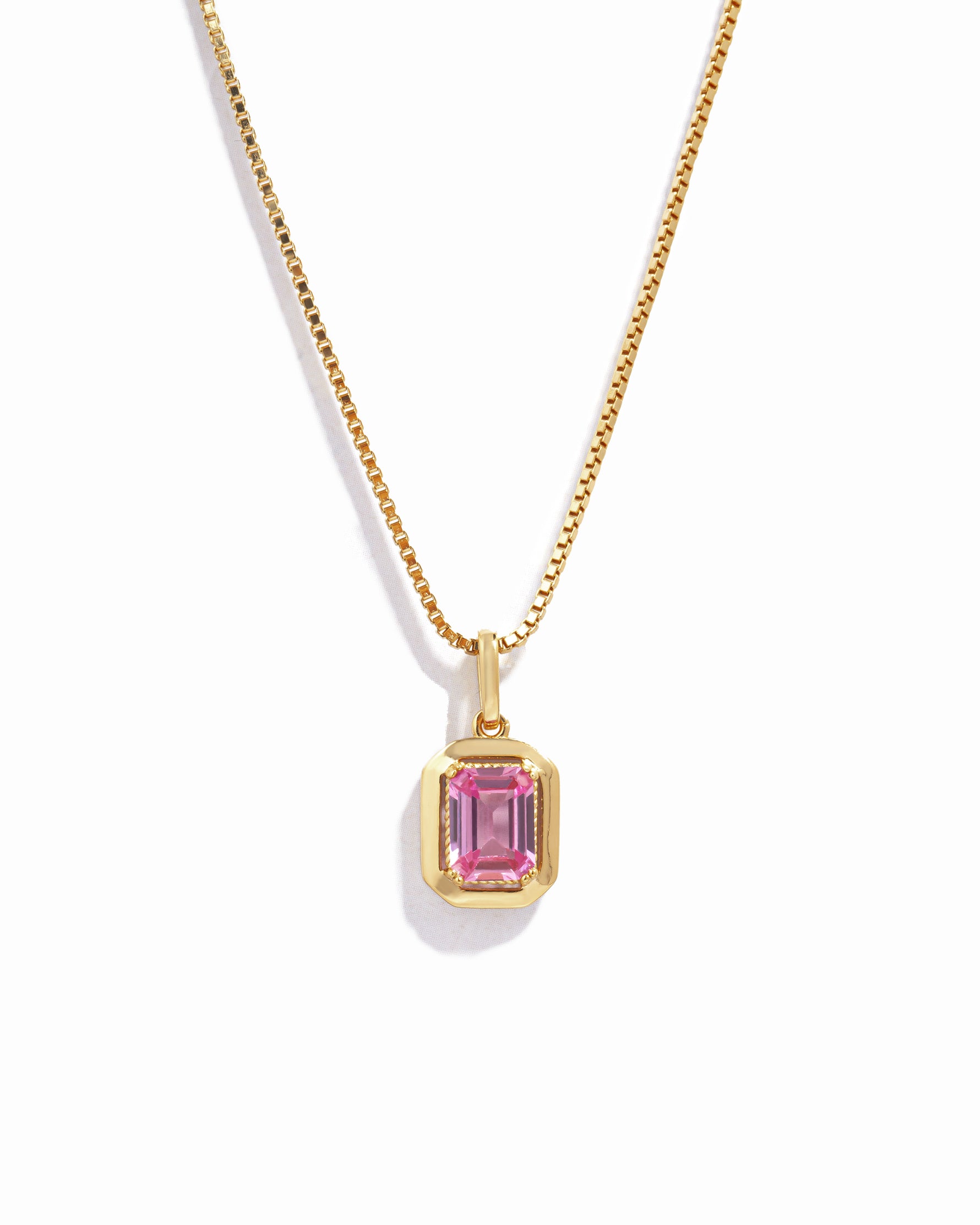gold pink necklace on box chain on white background