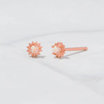 Upclose shot of rose gold dainty sunburst stud earrings with opal center.  