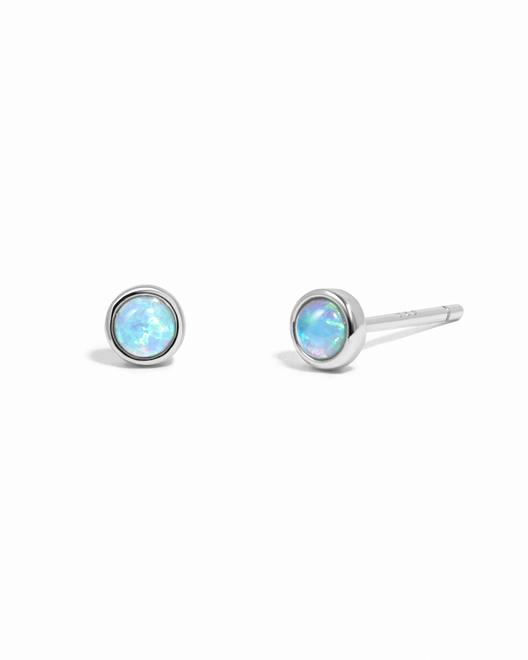 Sterling silver vibrant blue opal stud earrings on white background.