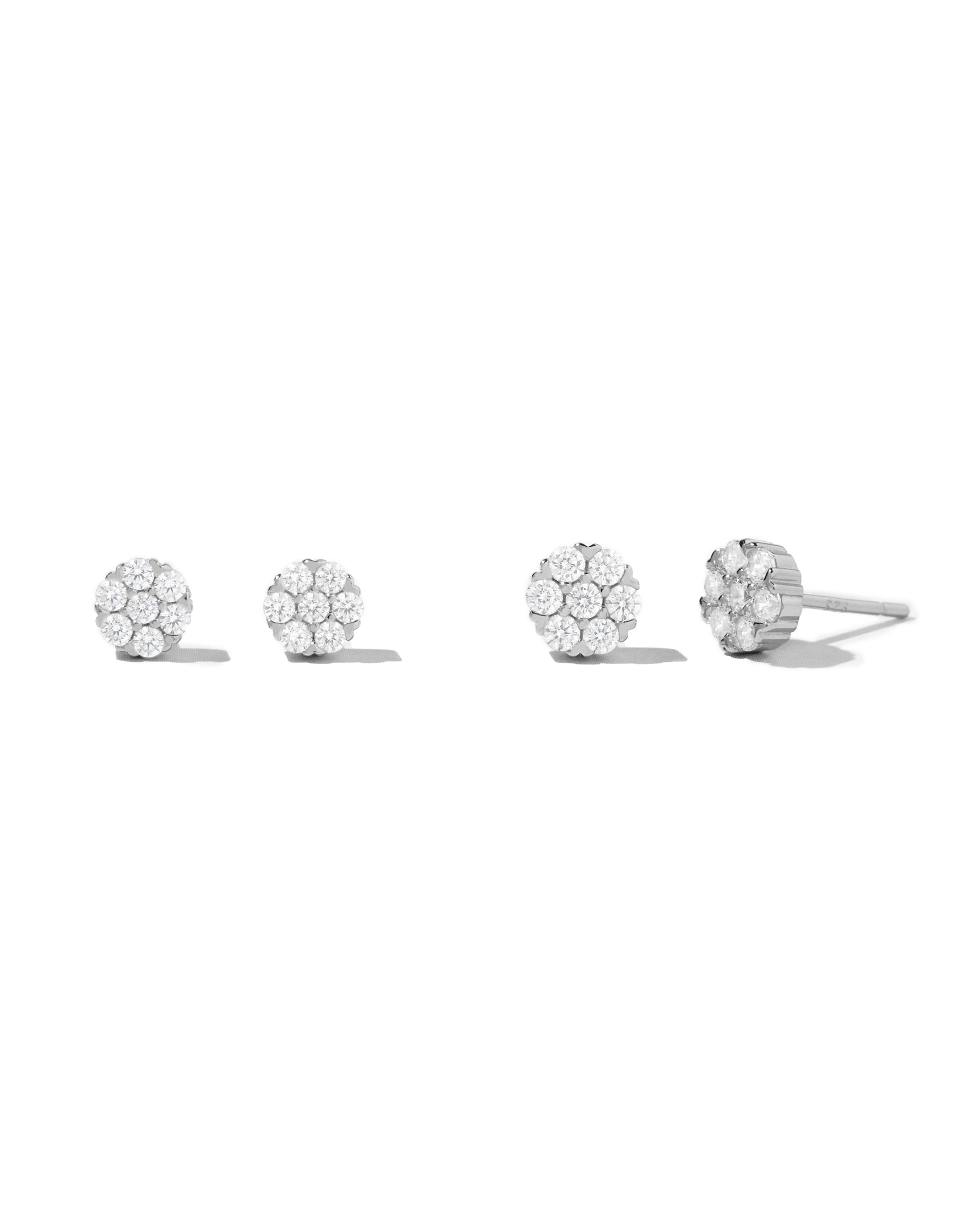Sterling silver big and small stud earrings on white background.