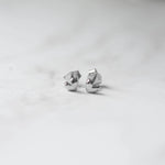 Closeup image of sterling silver small minimalist heart studs