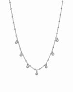 Sterling silver tear drop beaded charm necklace on white background.