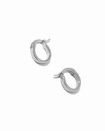 Delicate sterling silver small flat hoop earrings on white background.