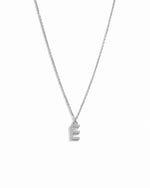 Dainty silver studded initial letter necklace on white background