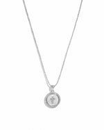 Silver mother of pearl cross necklace with a circular pendant from Sami Jewels, featuring elegant, shiny pearl accents.