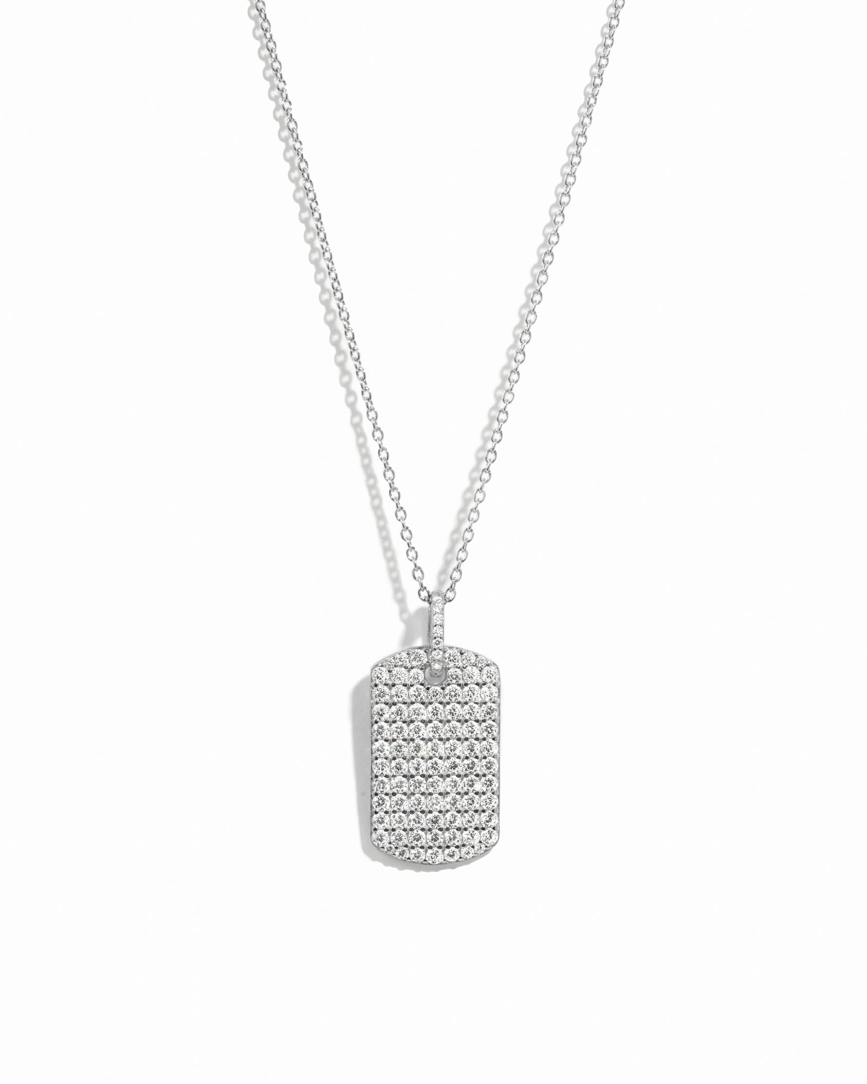 Silver pavé dog tag pendant necklace on white background.