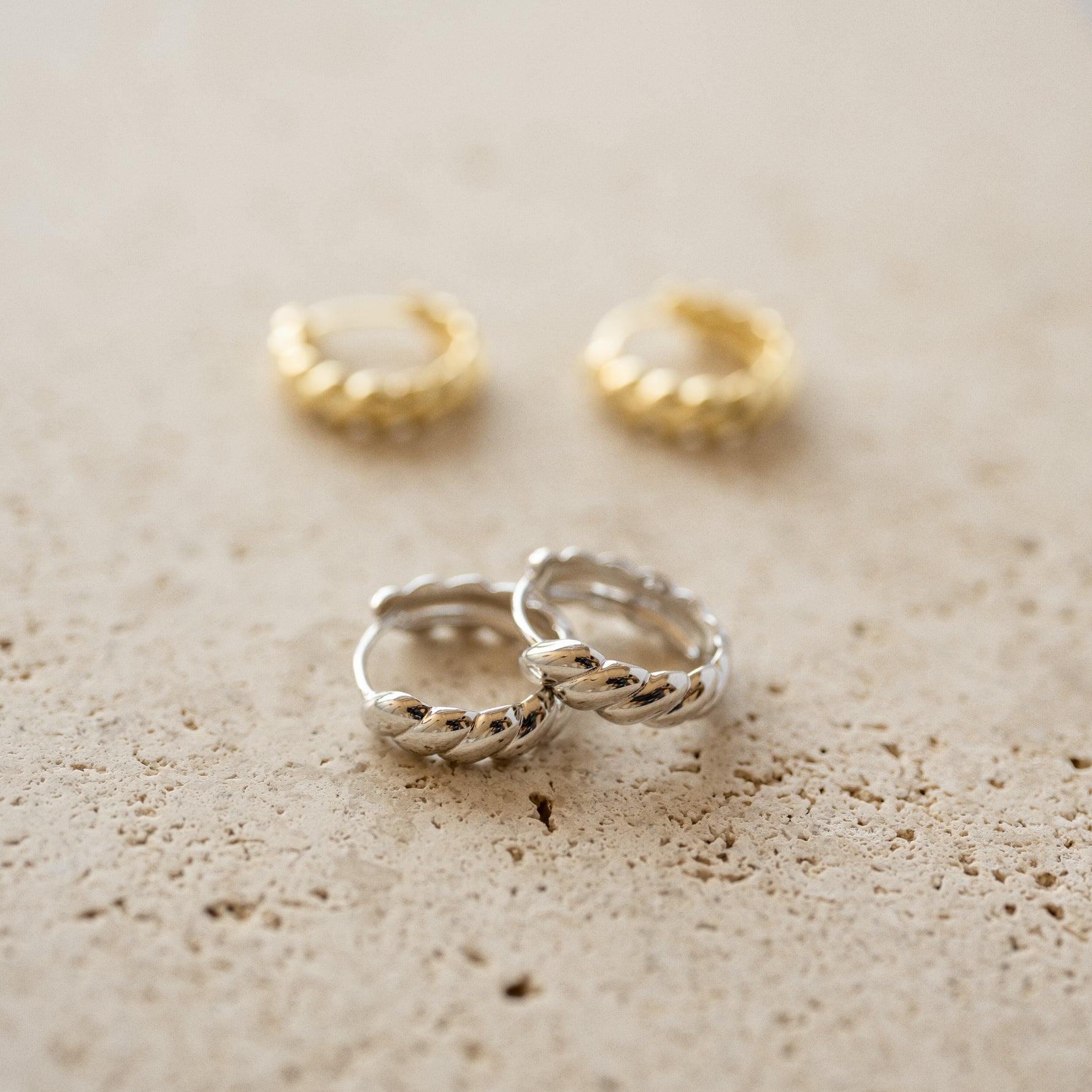 Close up shot of sterling silver croissant hoop earrings.