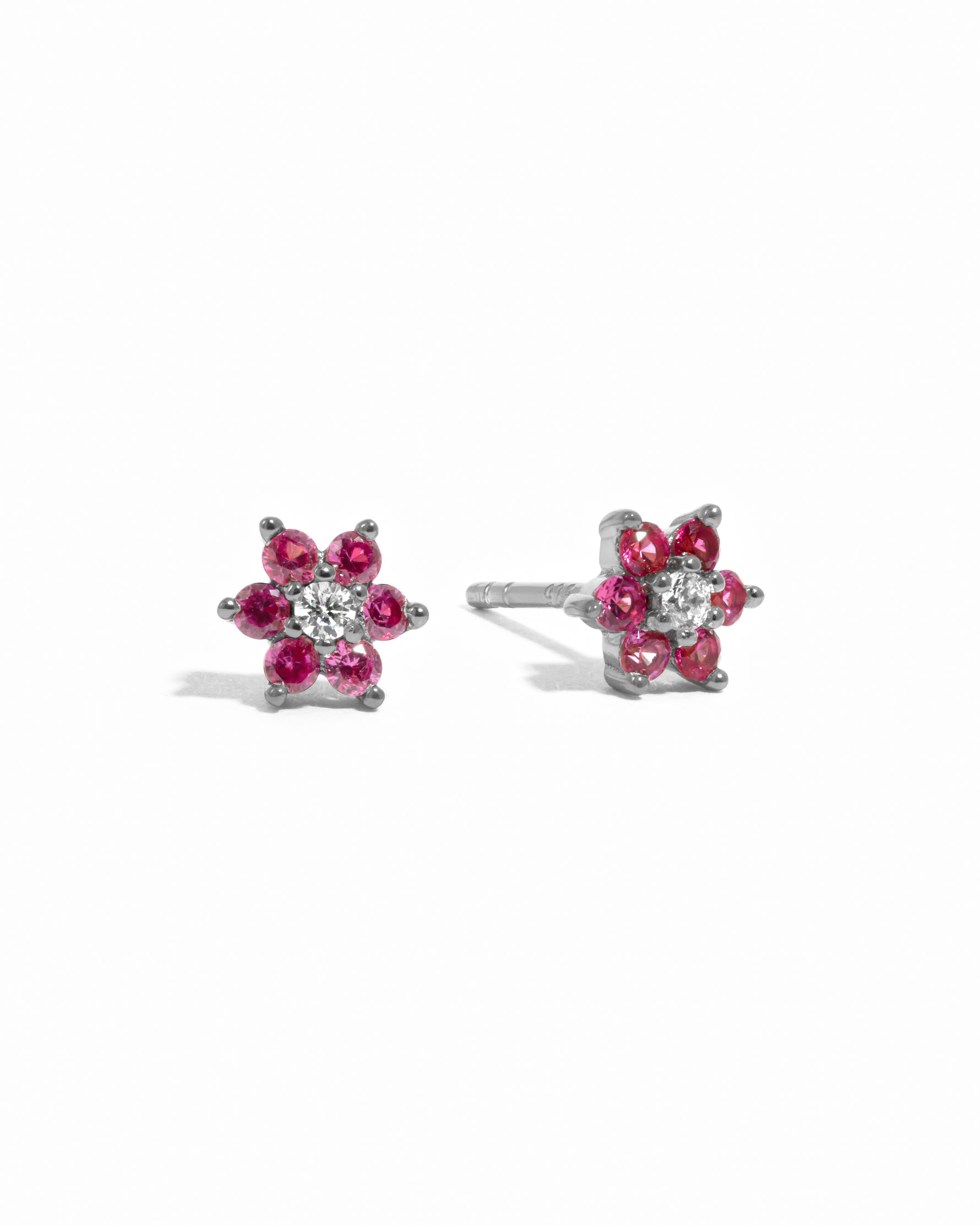 Sterling silver ruby birthstone flower stud earrings with diamond center. 