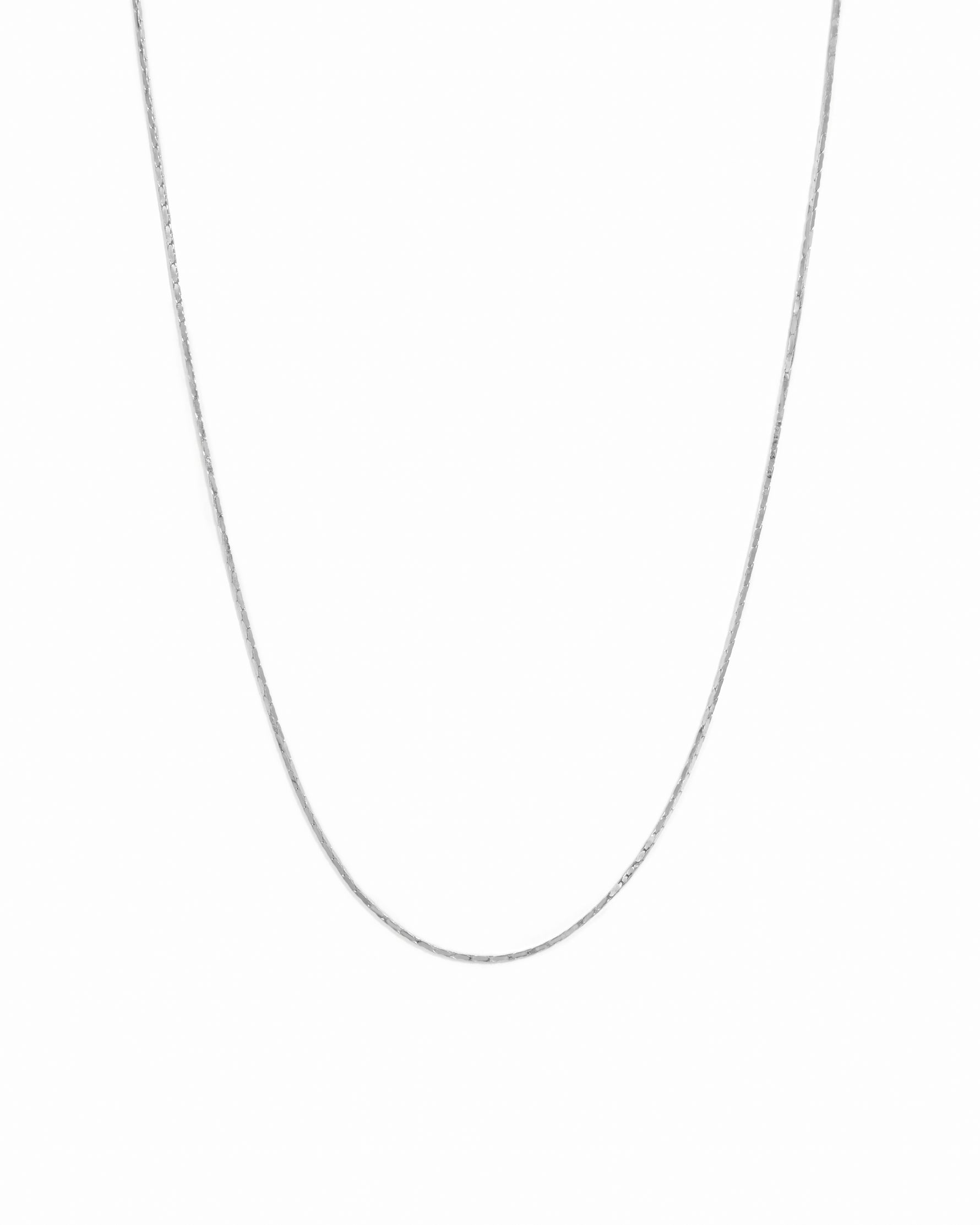 Sterling silver dainty thin chain necklace on white background.