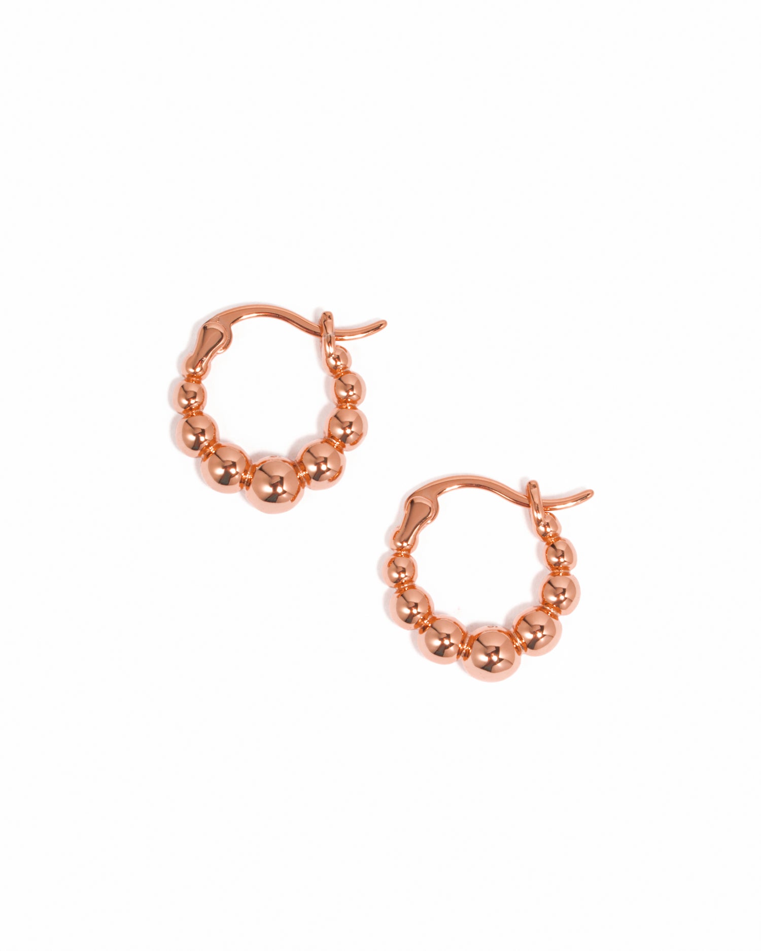Rose gold hoop earrings on a white background