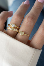 Model wearing feminine gold heart ring stack featuring a heart bezel ring and a heart eternity ring.