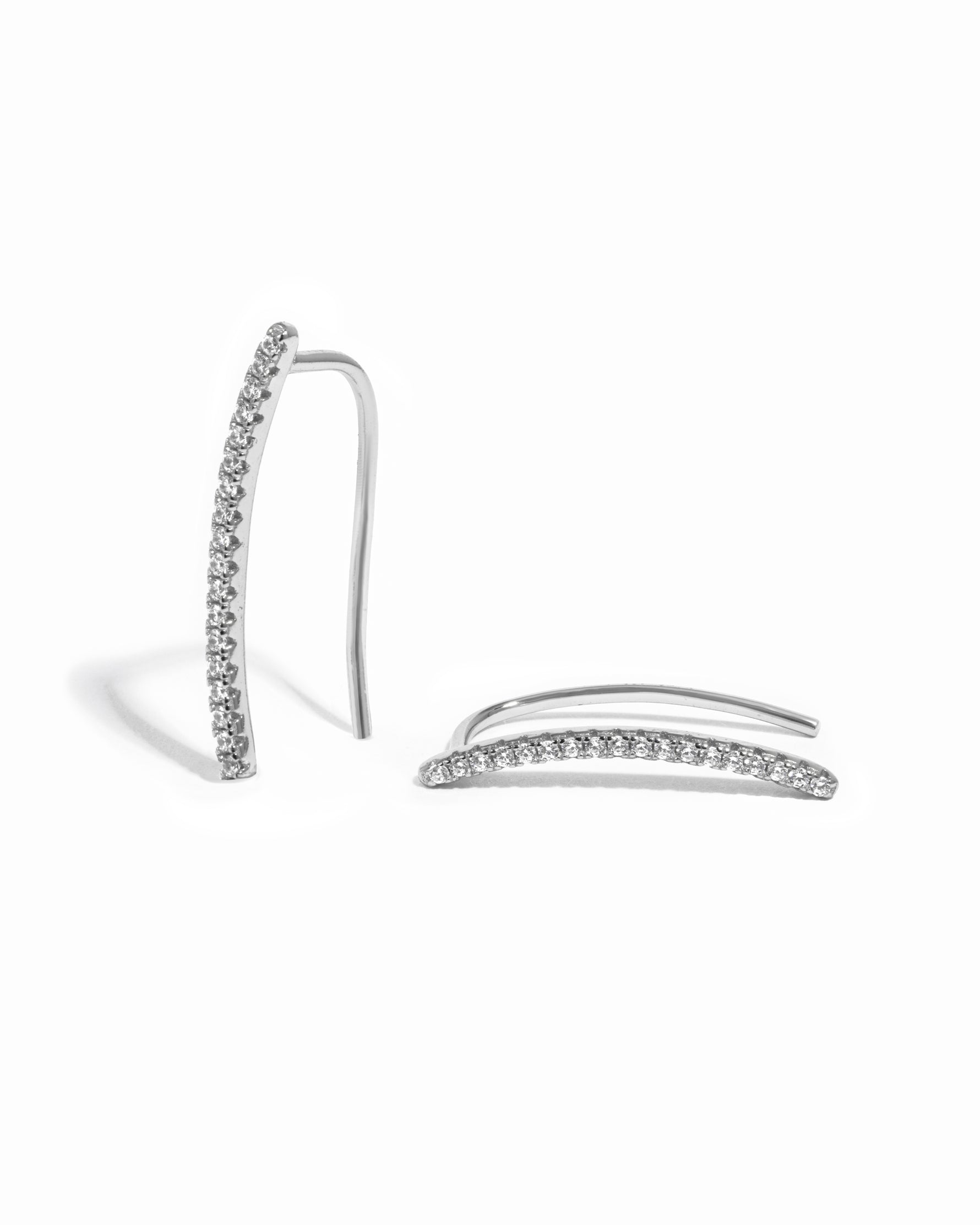 Delicate sterling silver studded cz ear climber on white background.