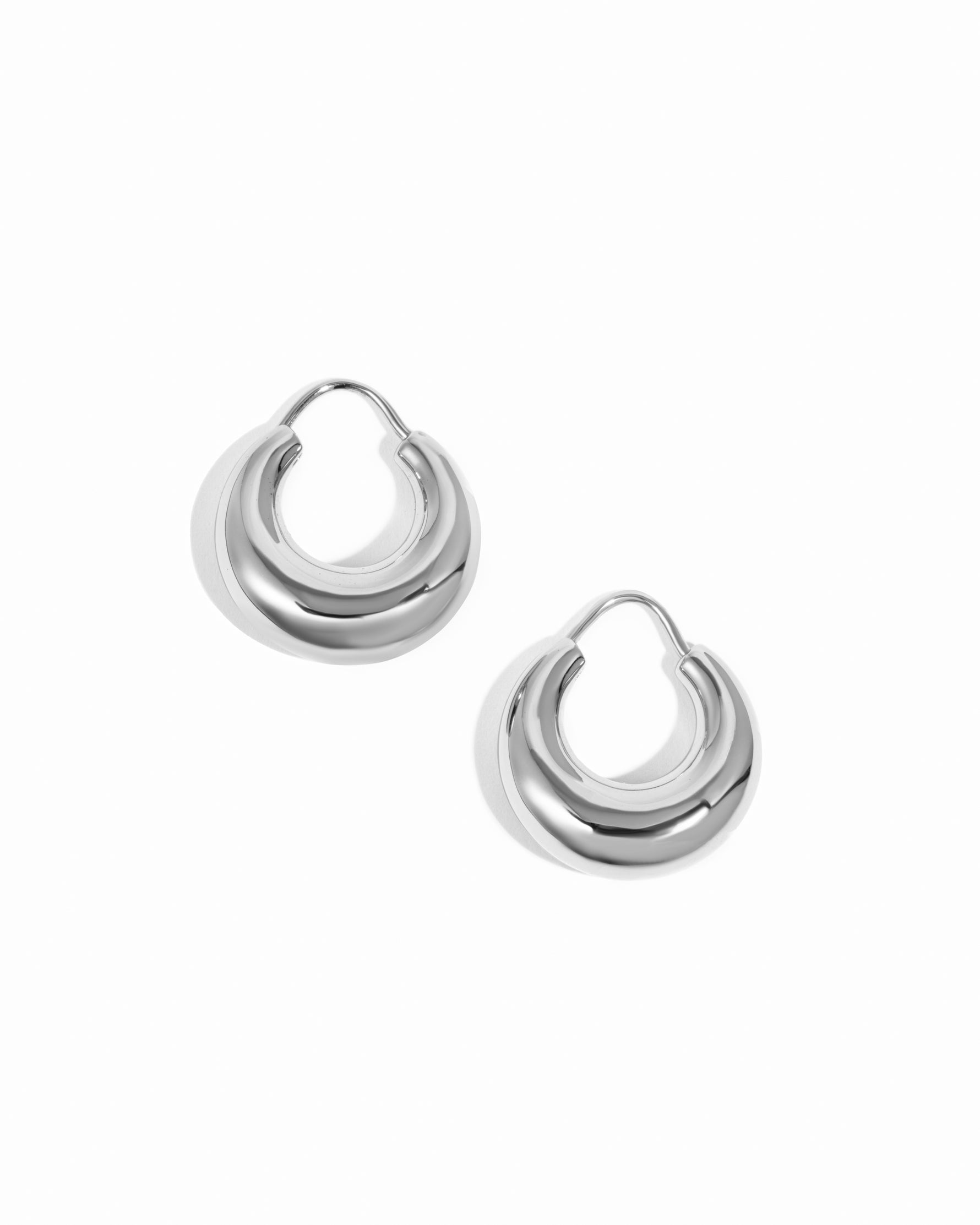 Sleek silver chunky basket hoop earrings on white background.