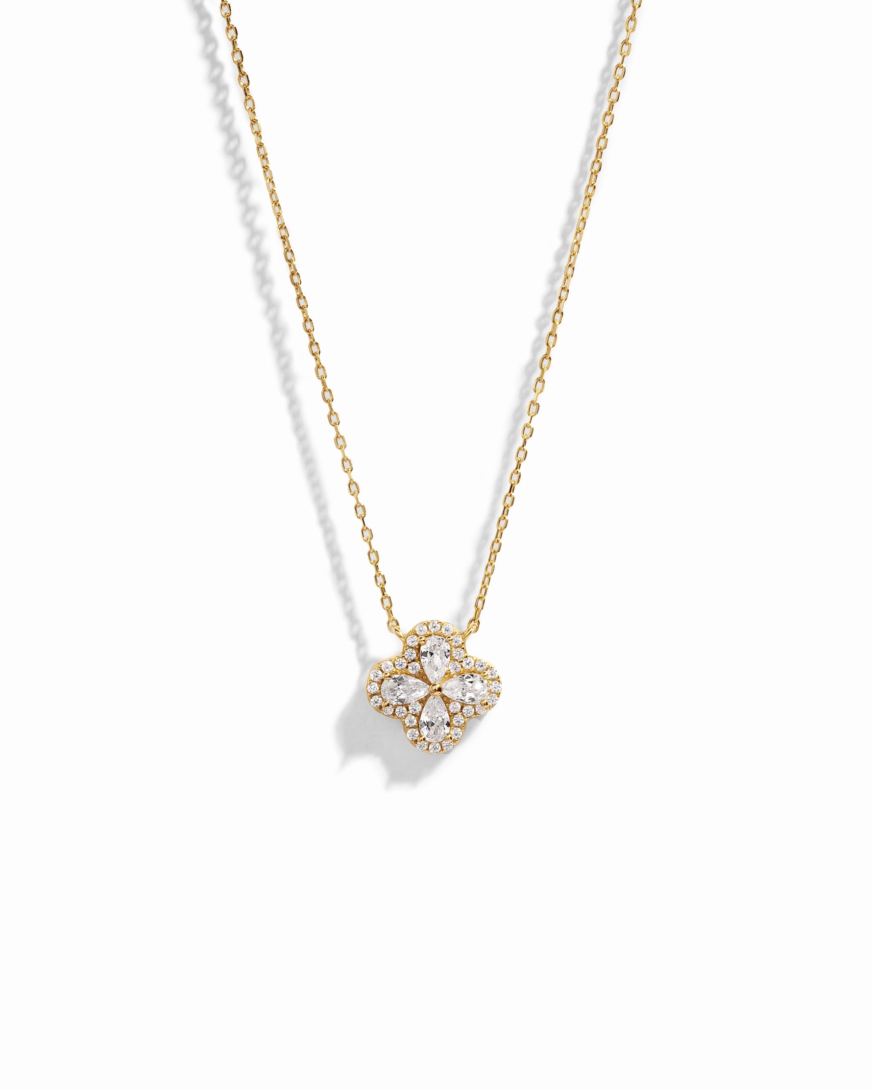 Close-up of four leaf clover pendant inspired by Van Cleef, highlighting intricate diamond details of pear shaped stones made of cubic zirconia.