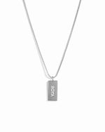 Sterling silver dainty dog tag customizable necklace on a box chain with a name on it.