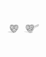 Silver delicate cz studded heart stud earrings on white background.