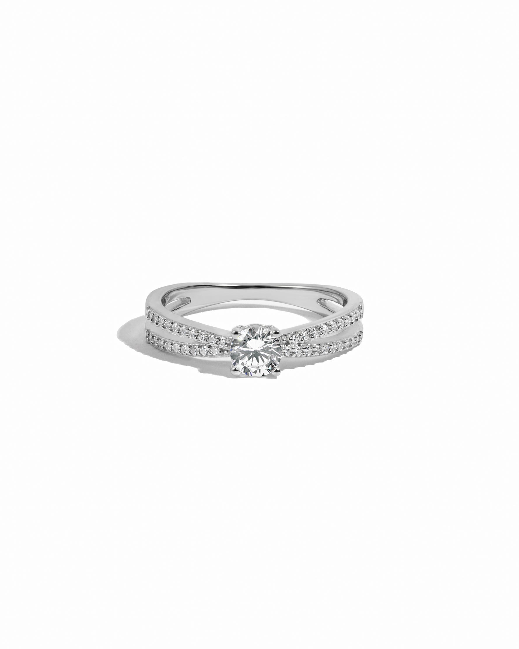 Sterling silver split shank round solitaire diamond ring on white background. 