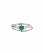 Emerald marquise birthstone ring in silver on white background.