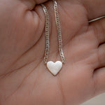 Silver heart pendant necklace on chain link necklace.