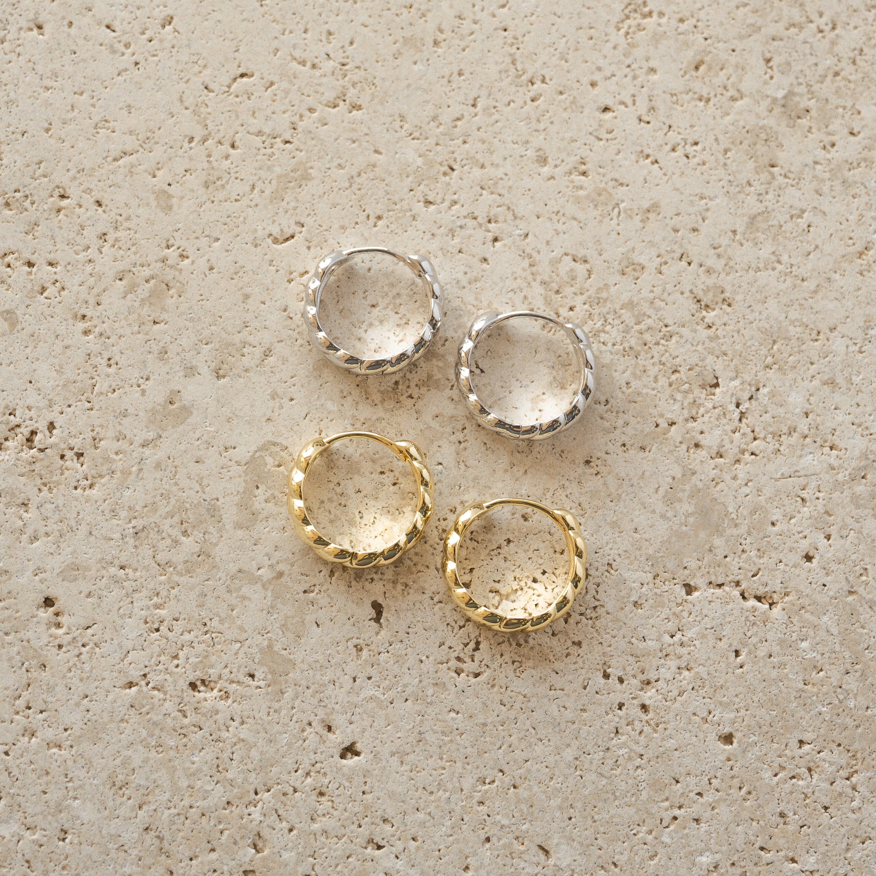 Gold and silver croissant textured hoop earrings. 