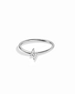 Minimalist silver lightning bolt cz ring on white background.