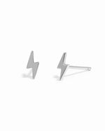 Dainty silver lightning bolt stud earrings on white background.