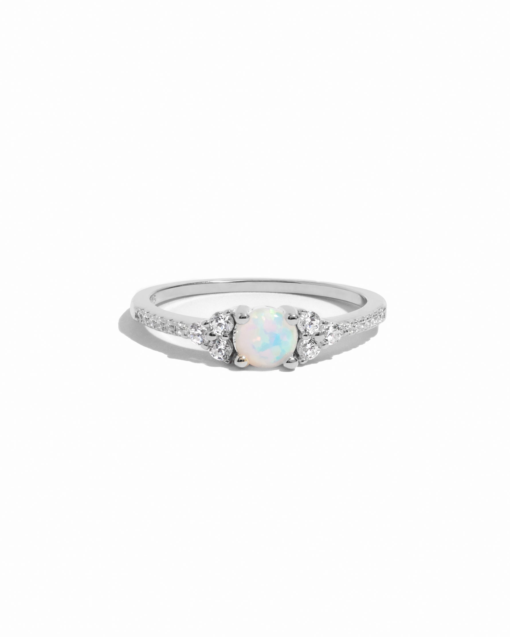 Sterling silver dainty opal birthstone ring with cz stones on white background. 