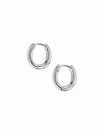 Minimalist oval silver huggie hoops on white background