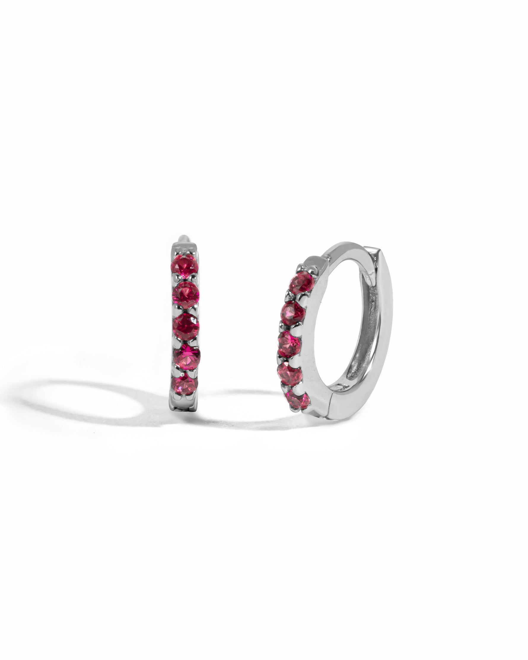 Sterling silver birthstone ruby huggie earrings.