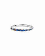 Delicate sterling silver sapphire eternity ring on white background. 