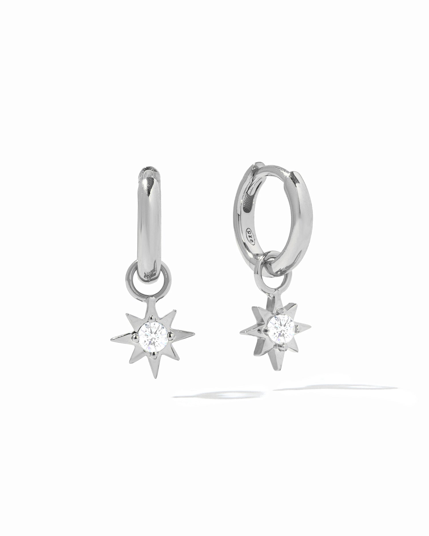 Dainty silver sunburst charm earrings with removable charm on white background.