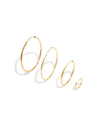 Set of gold hoop earrings on a white background