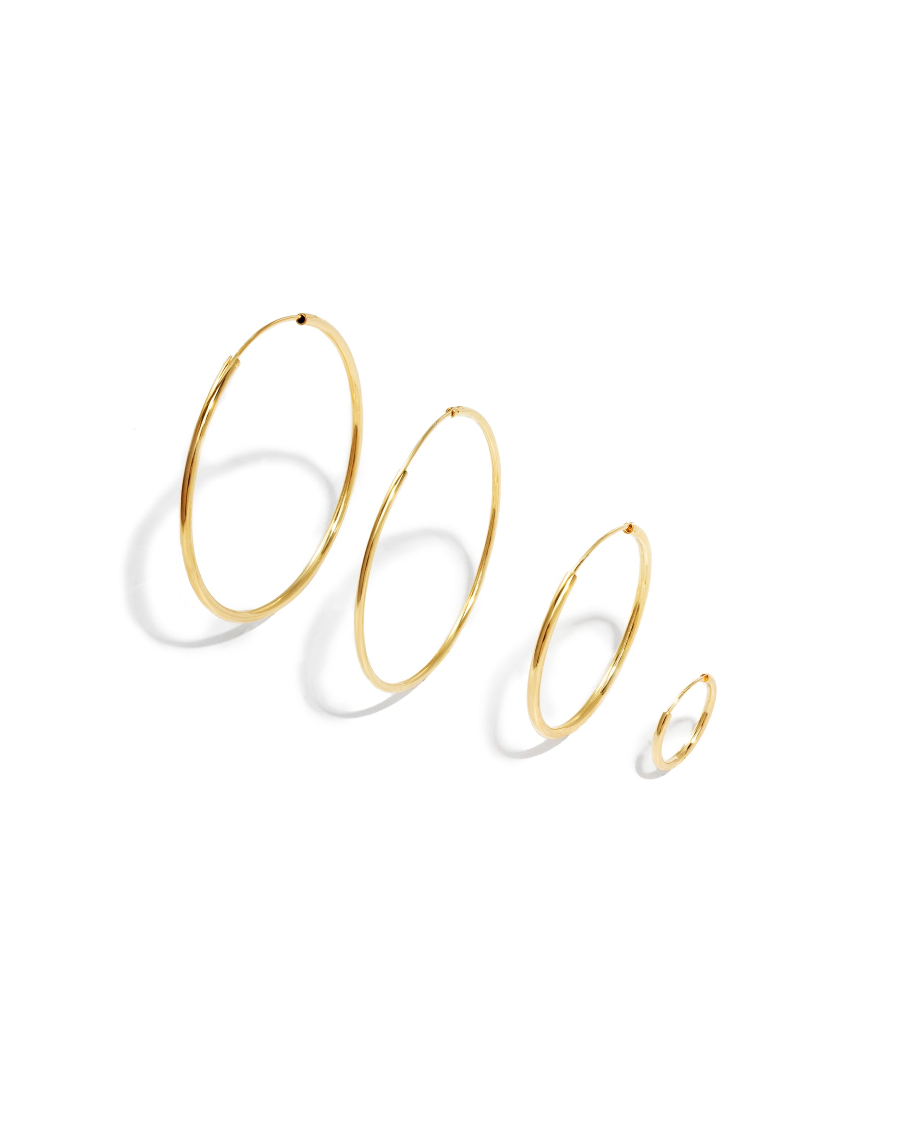 Set of gold hoop earrings on a white background