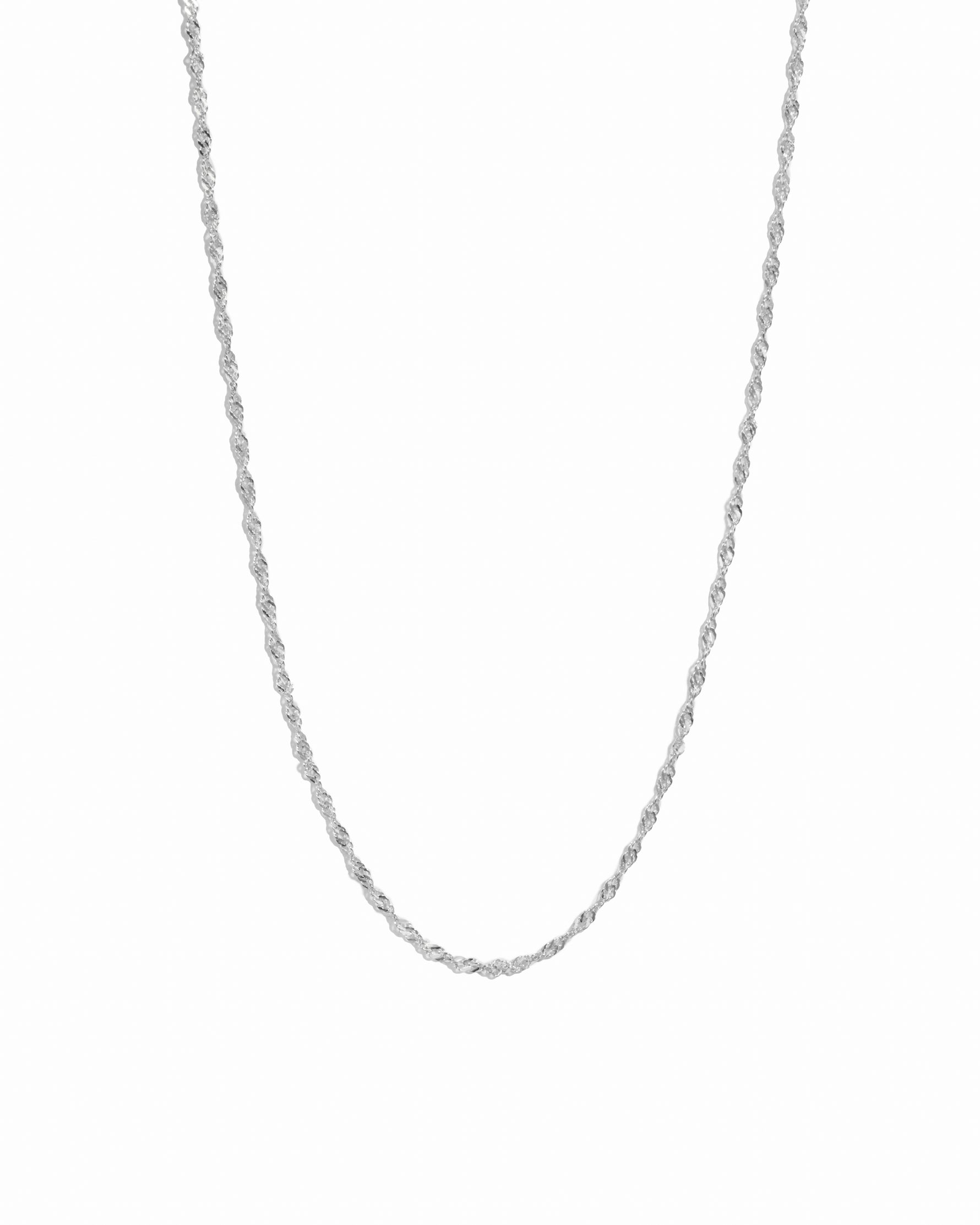 Silver dainty thin twisted chain necklace on white background.