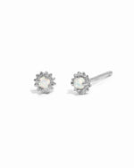 Dainty sterling silver opal center sunburst stud earrings on white background.