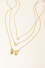 Gold butterfly necklace stack featuring a dainty tiny bezel necklace, a cz butterfly necklace, and a statement butterfly necklace. 