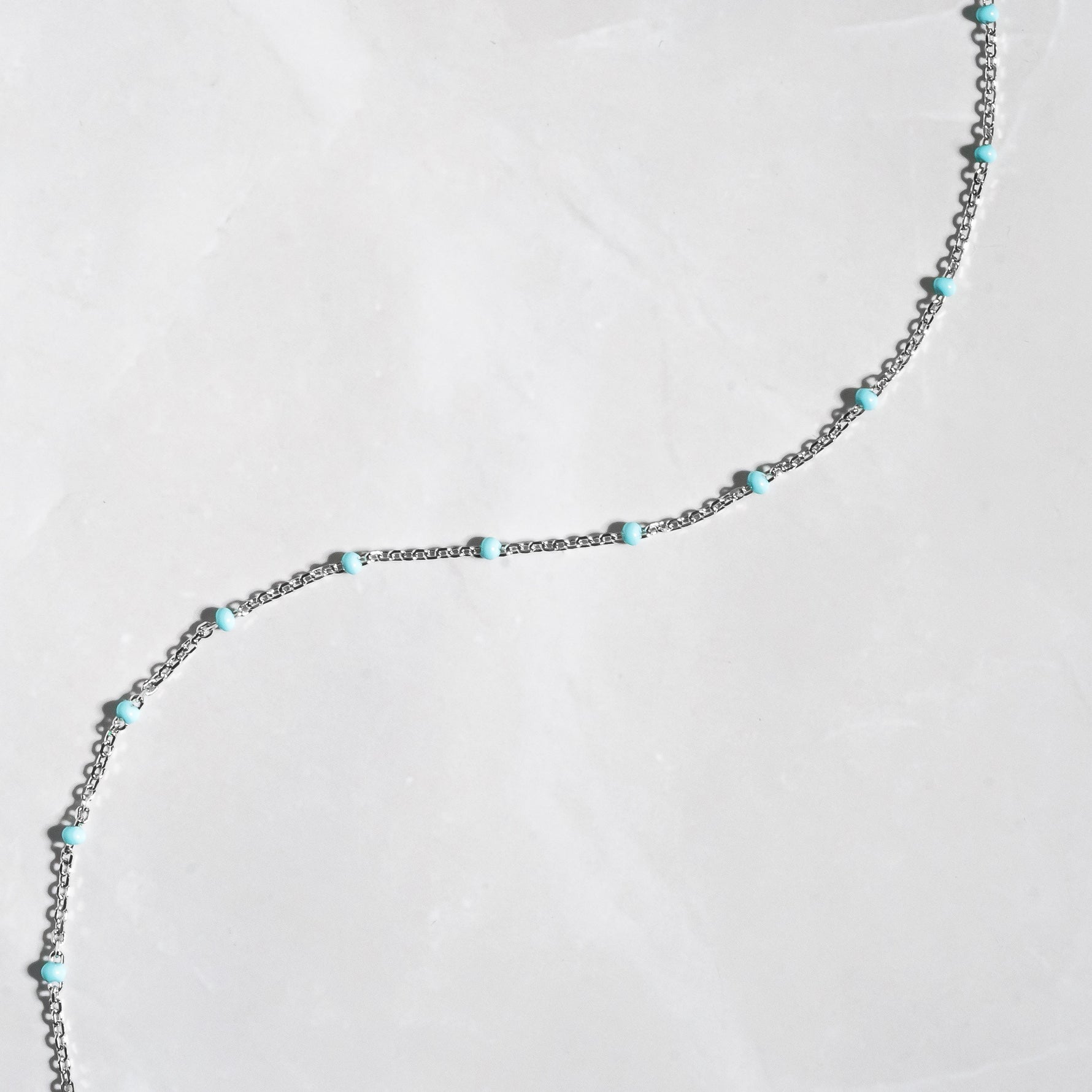 Up close image of silver turquoise simple beaded anklet